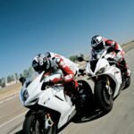 two people riding sports bikes on gray asphalt road during daytime